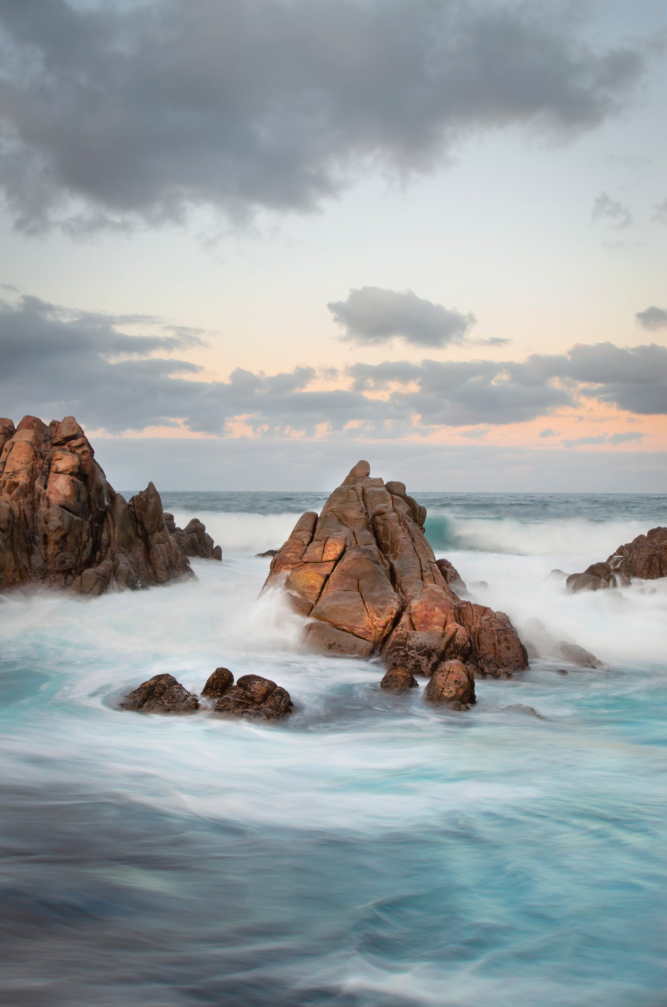 Swirling waters around isolated rock formation.