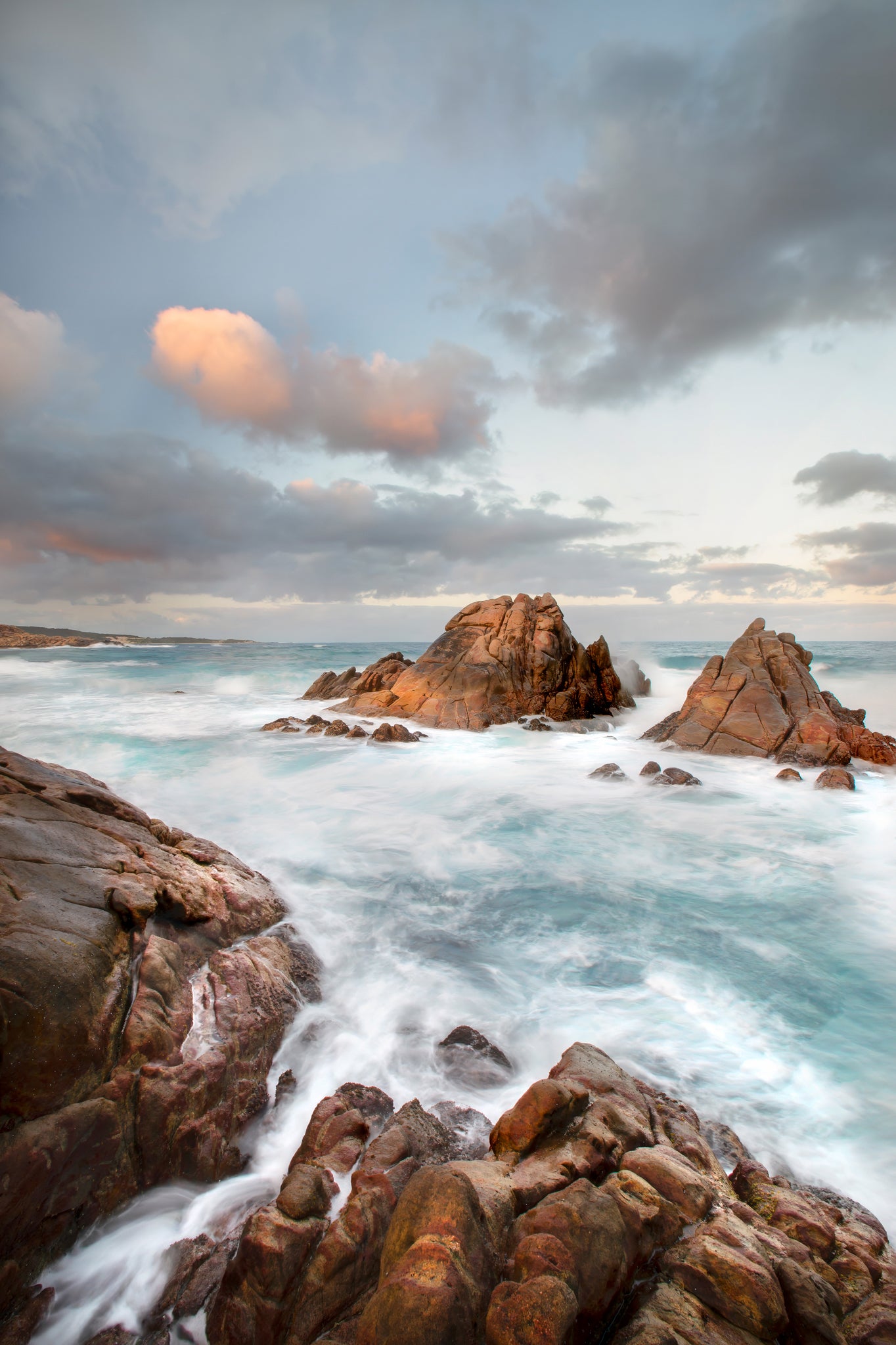 Rugged Canal Rocks coastline with ocean surges under a dramatic sky.