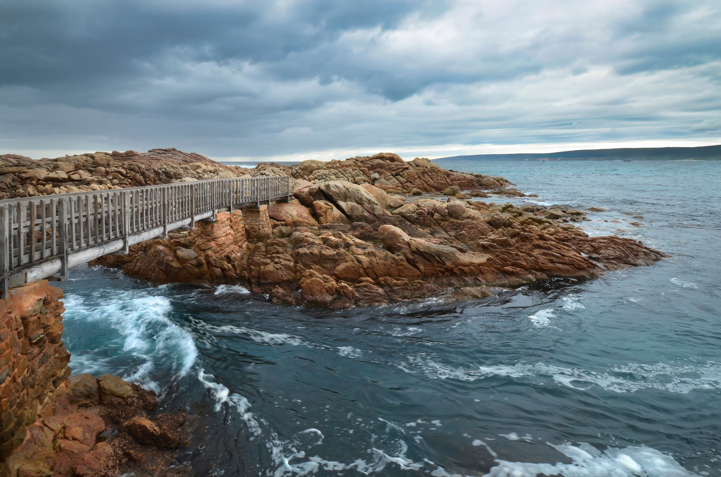 Bridge at Canal Rocks framed by dramatic granite and moody atmosphere.