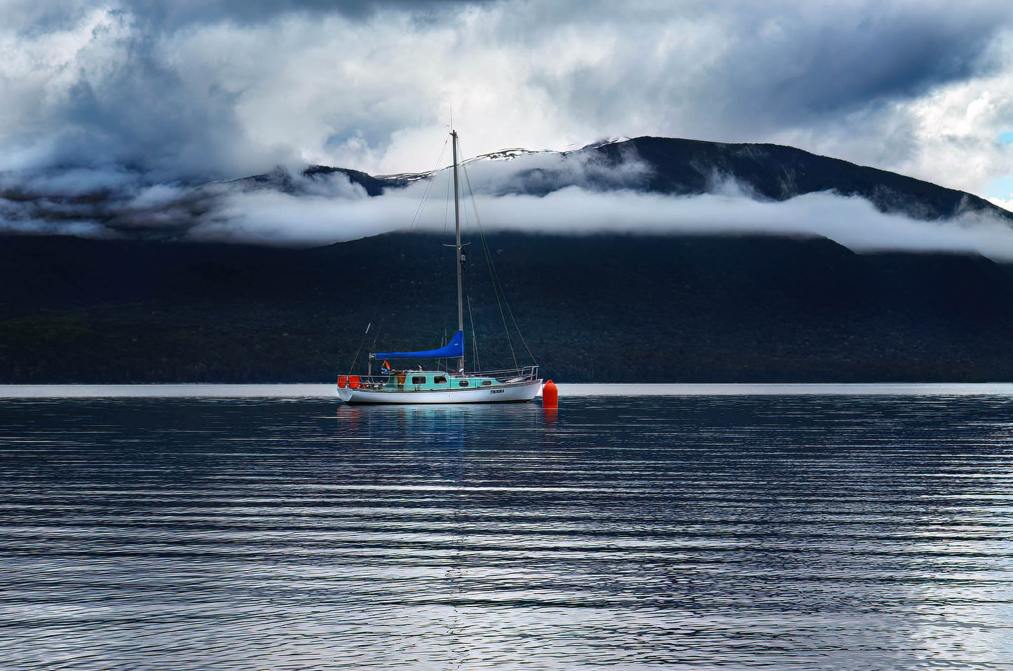 Boat on a calm lake with mountains in the background
