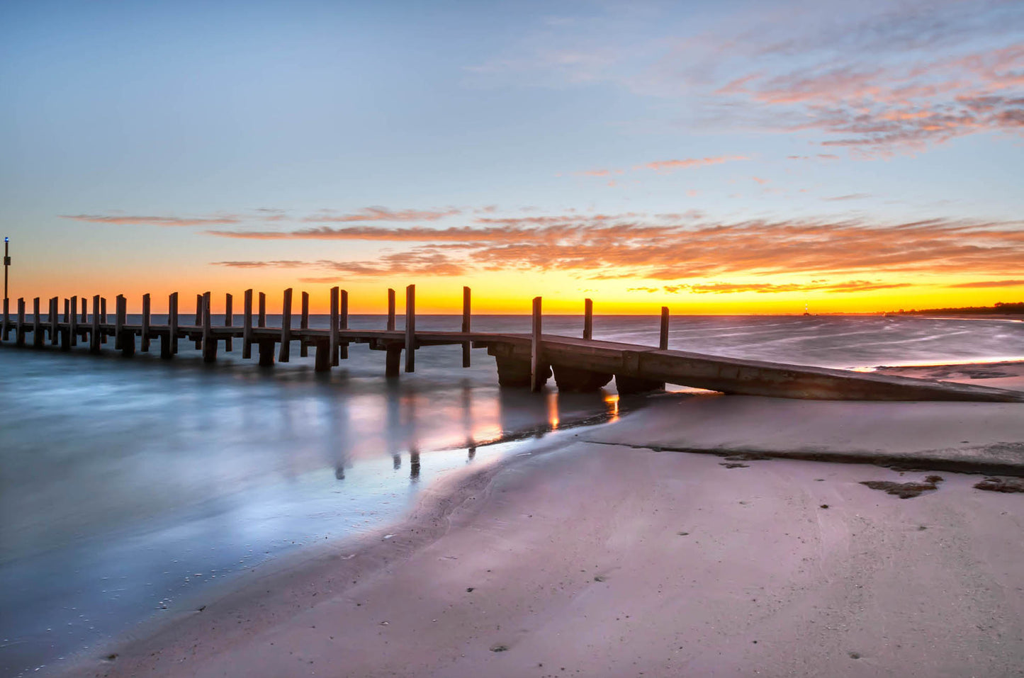 Sunrise over Quindalup Boat Ramp with calm turquoise water and timber jetty.