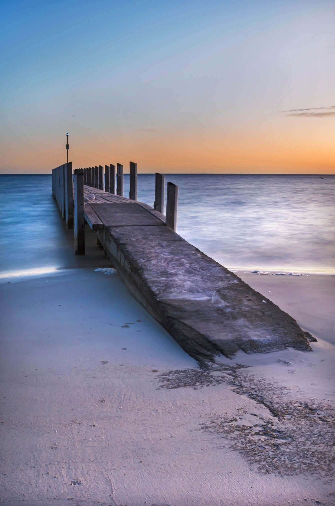 Weathered jetty leading into blue water at Quindalup Boat Ramp.