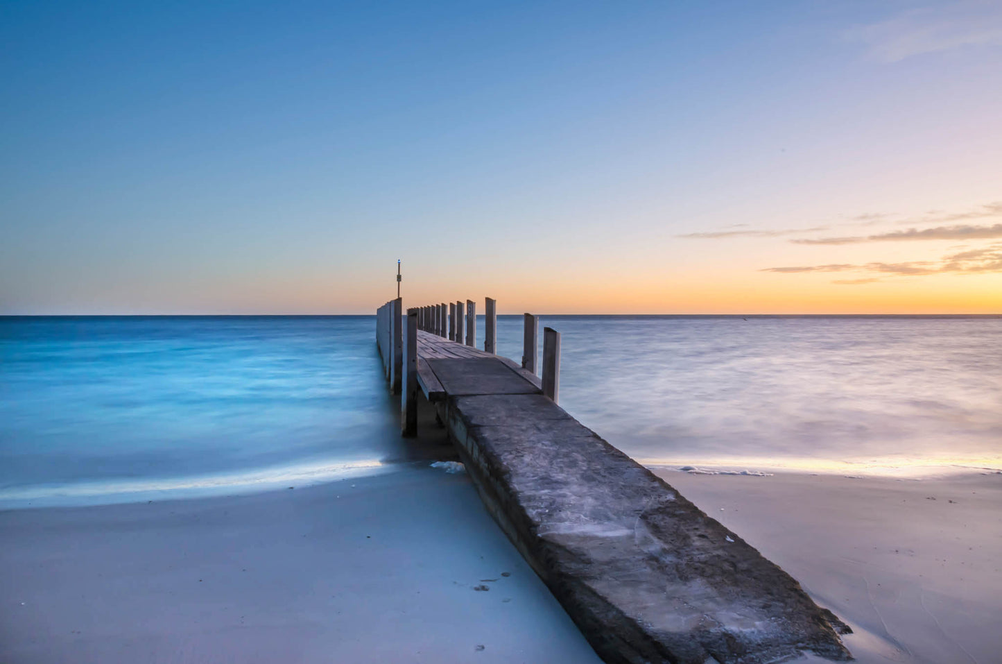 Minimalist seascape featuring Quindalup jetty and glassy water in the bay.