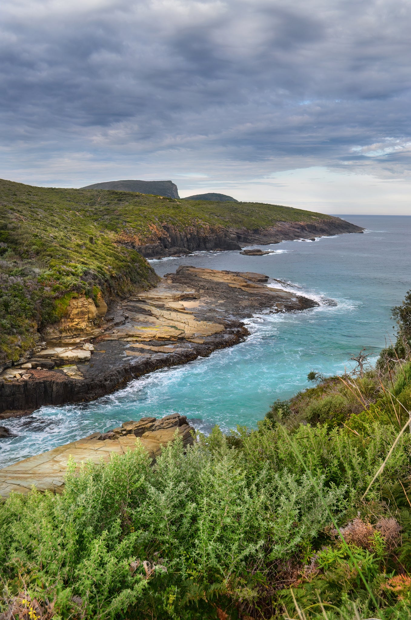 Wide-angle seascape of the rugged Tasman Peninsula coastline surrounding Remarkable Cave, Tasmania.