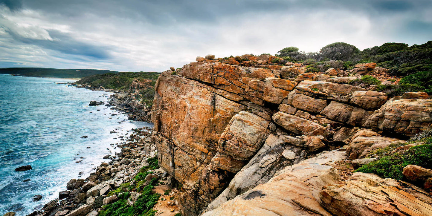 Wilyabrup rocky sea cliffs and ocean waves under a cloudy sky.
