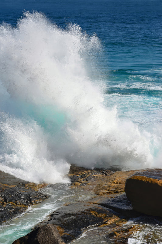 Towering spray erupting against granite headlands.