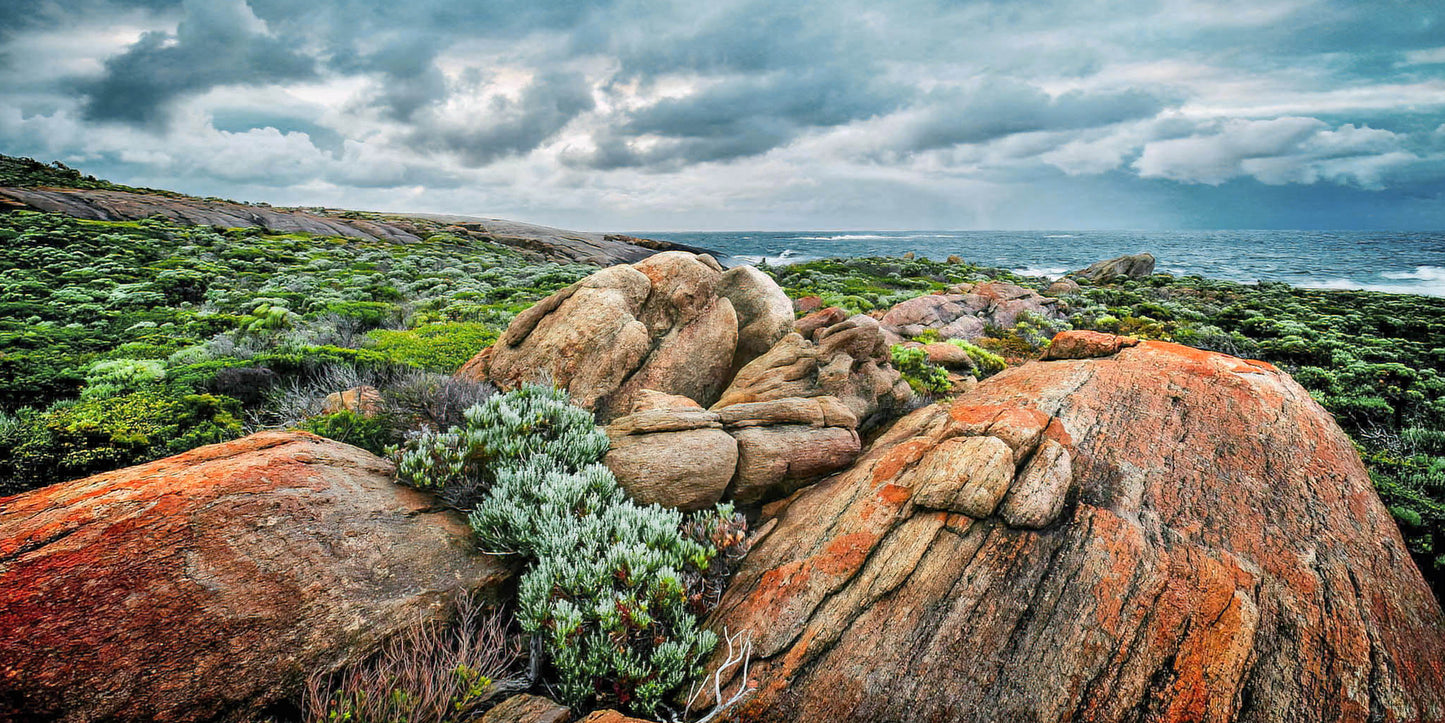 Rocks and coastal landscape with ocean and cloudy sky at Augusta