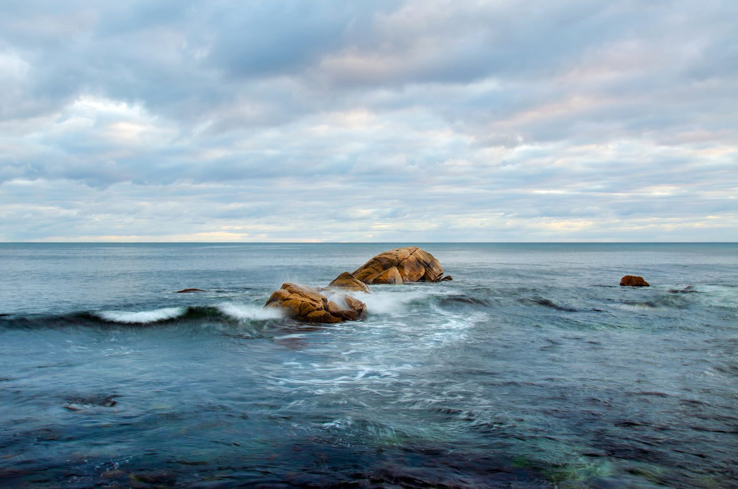 Slow ocean movement with a pastel sky.