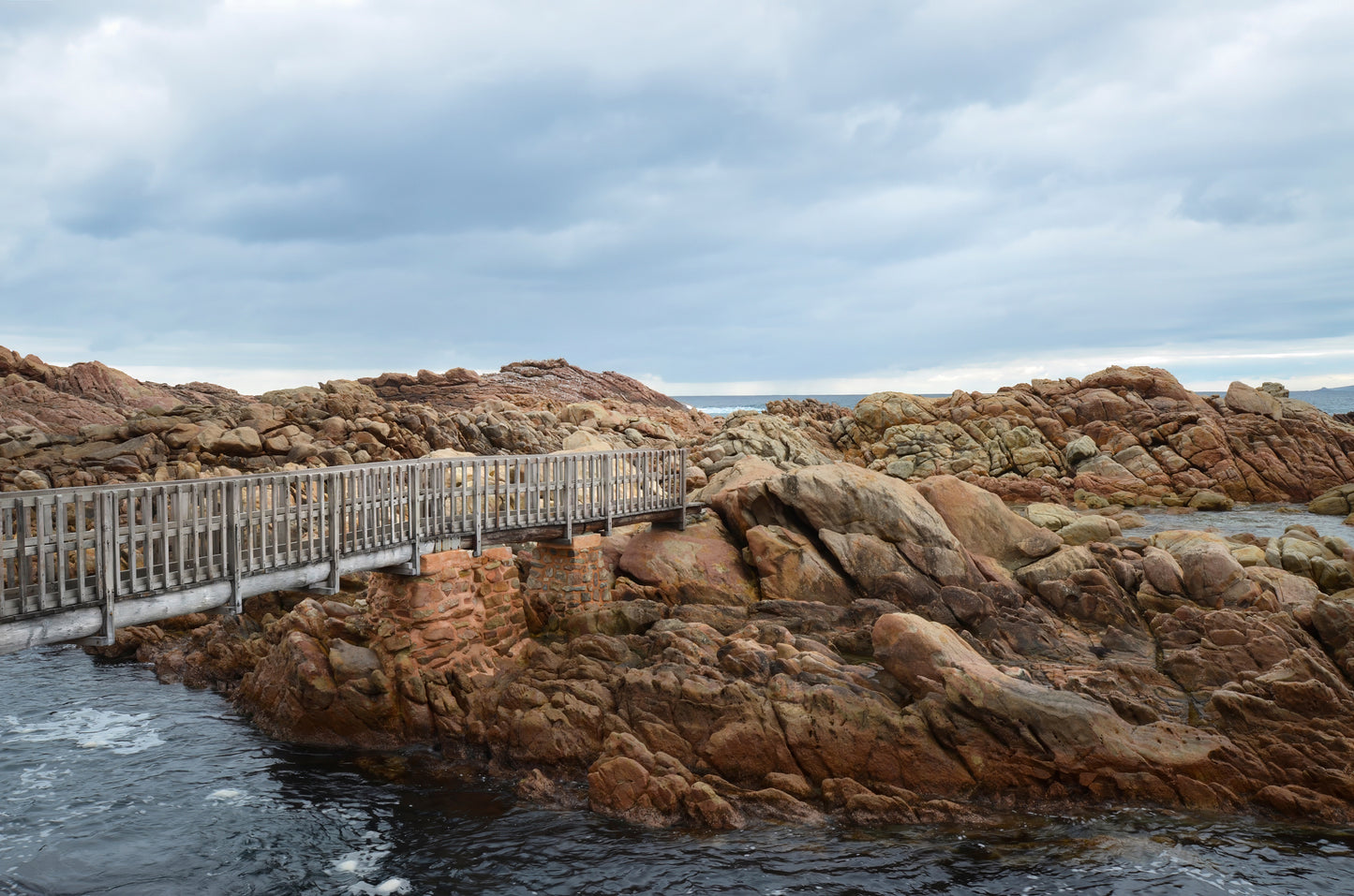 Wide-angle view of the timber walkway at Canal Rocks, with sweeping perspective and layered rocks.