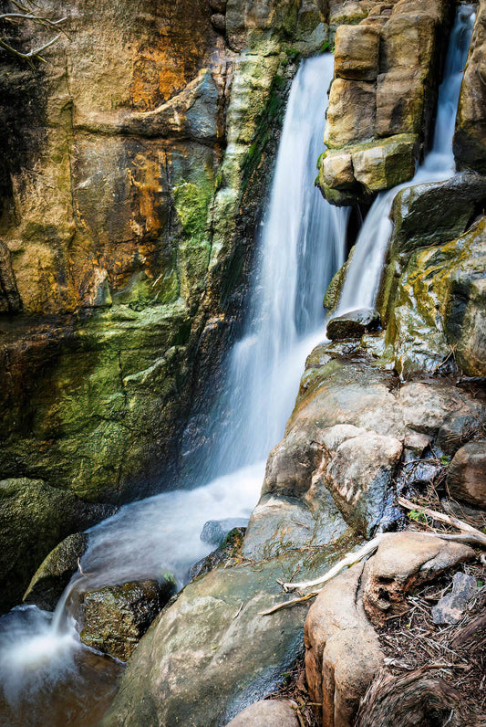 Waterfall cascading down rocky ledges in a secluded location.