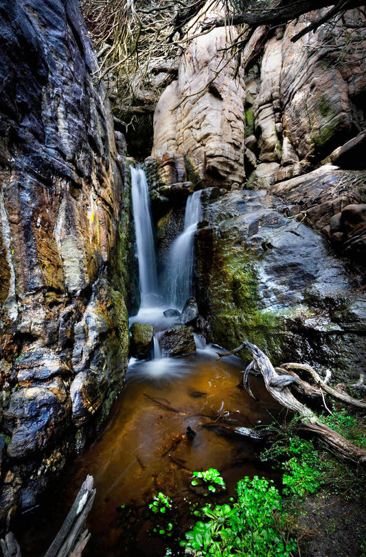 Waterfall cascading down rocky cliffs with greenery