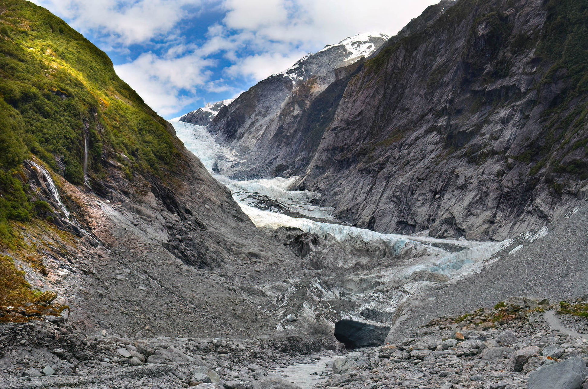 Glacier flowing through a valley with mountains in the background
