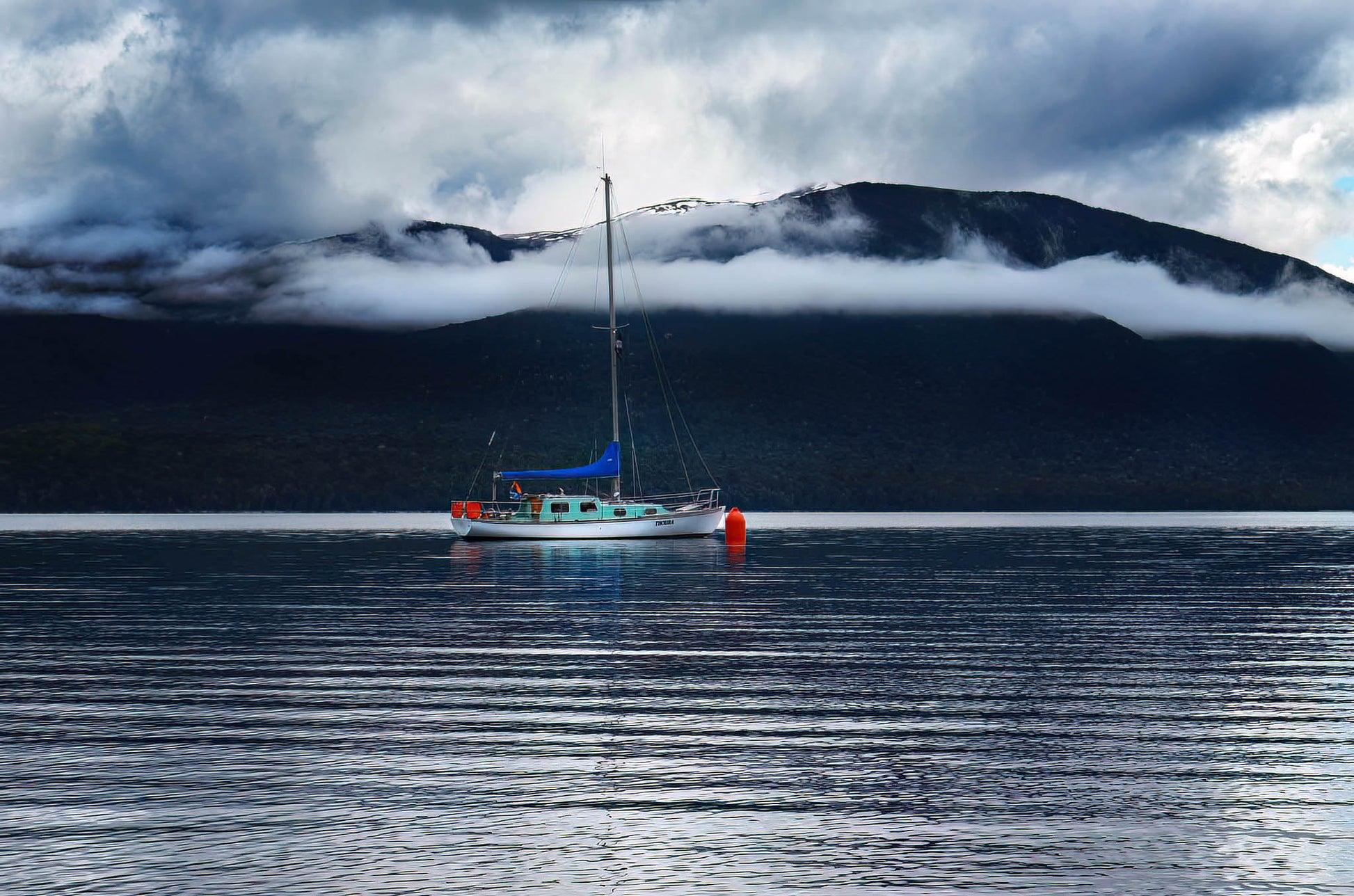 Boat on a calm lake with mountains in the background