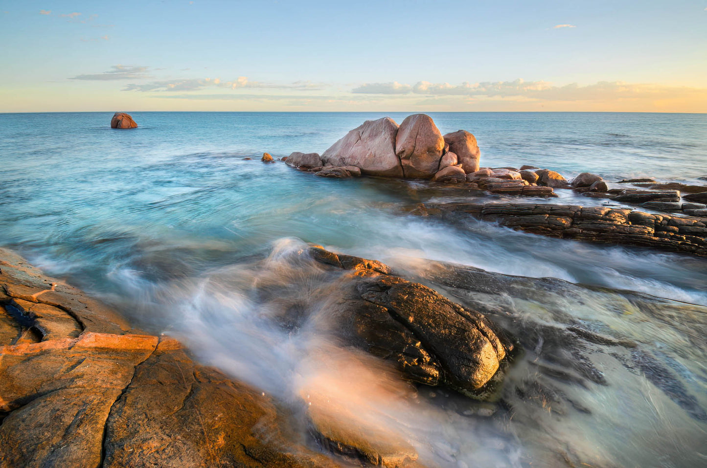 Rocks and waves at a beach with a clear sky