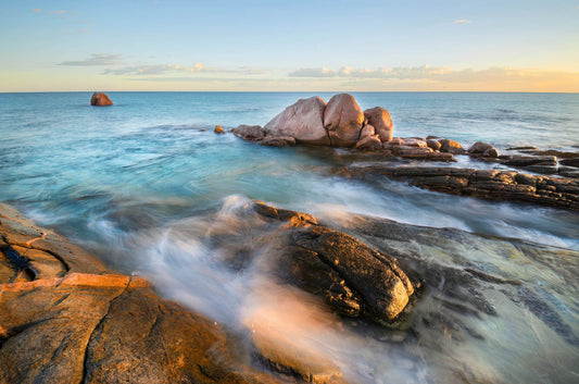 Rocks and waves at a beach with a clear sky