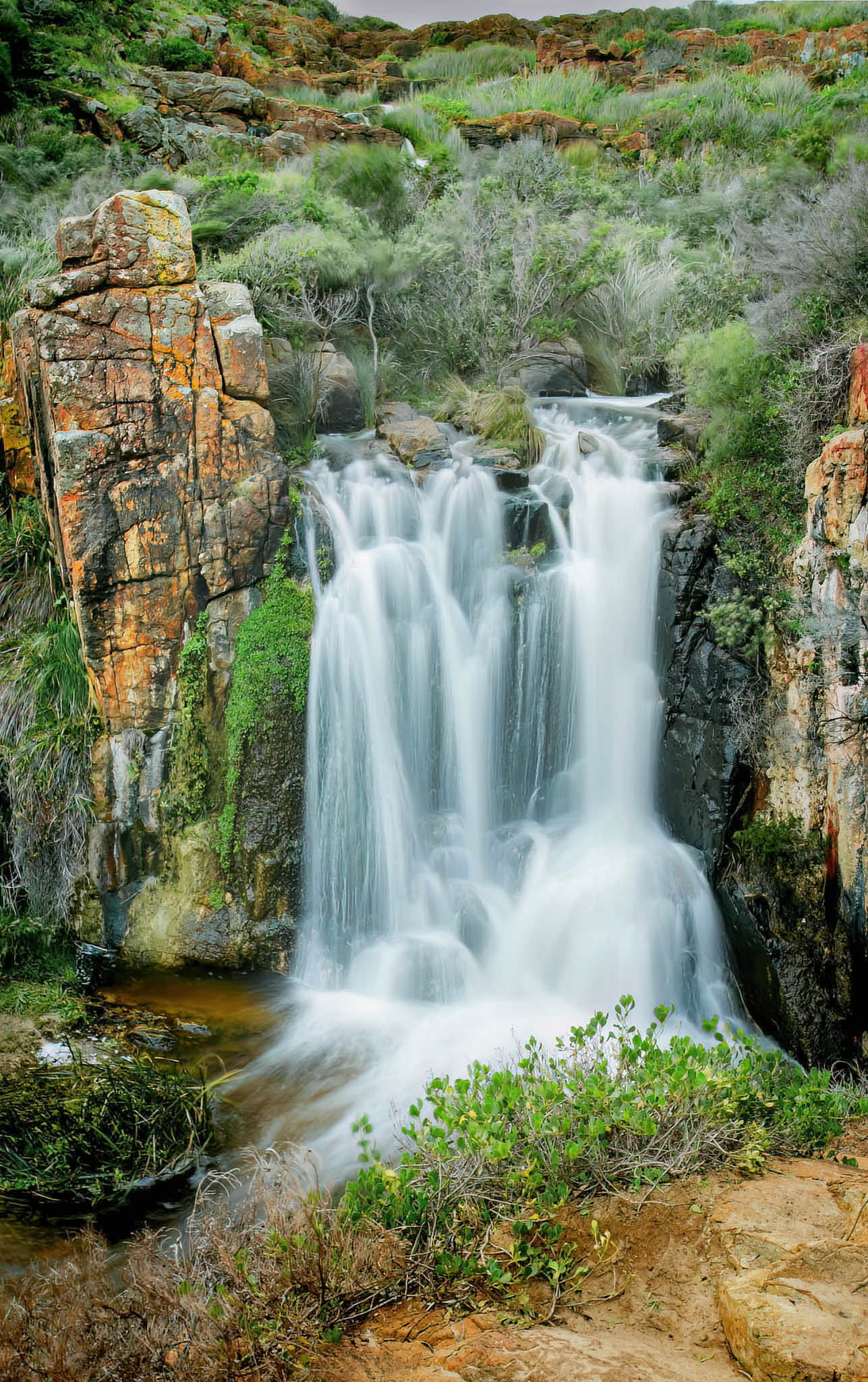 Quinninup waterfall cascading down rocky cliffs with greenery in a natural setting