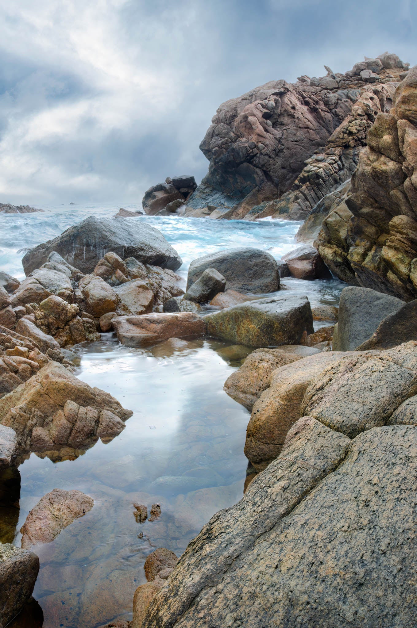 Coastal vista of Smiths Beach cliffs with rockpool in the foreground.