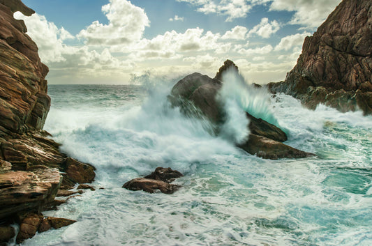 Stormy ocean swell breaking around Sugarloaf Rock.