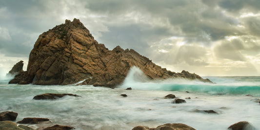Powerful Indian Ocean waves surging around Sugarloaf Rock during high tide.