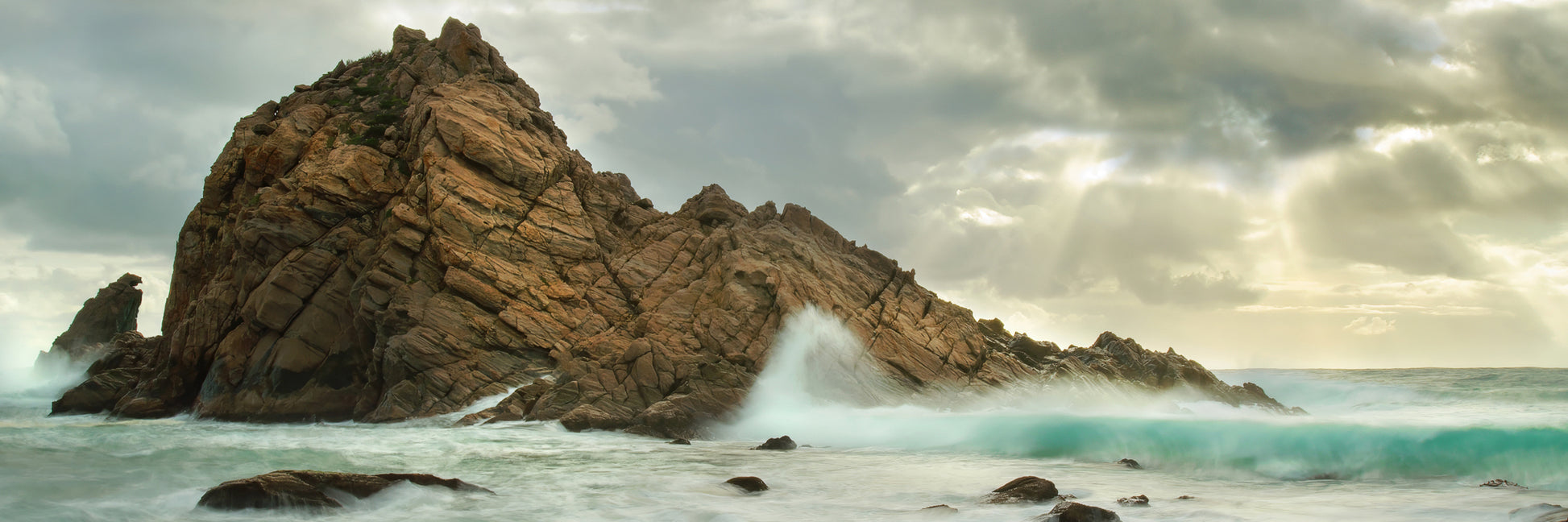 Powerful Indian Ocean waves surging around Sugarloaf Rock during high tide.