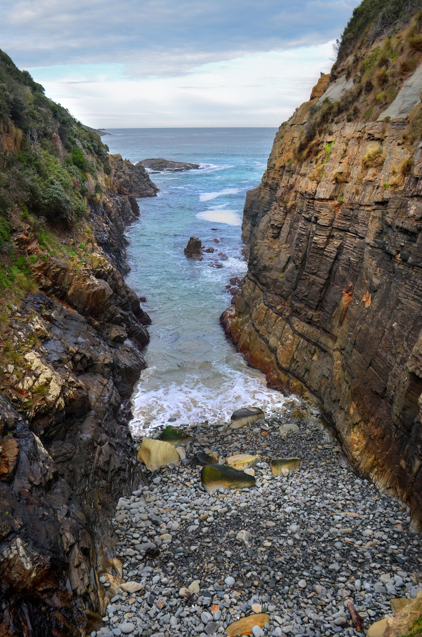 Surging tide through sandstone cliffs near Remarkable Cave on Tasmania's Tasman Peninsula.