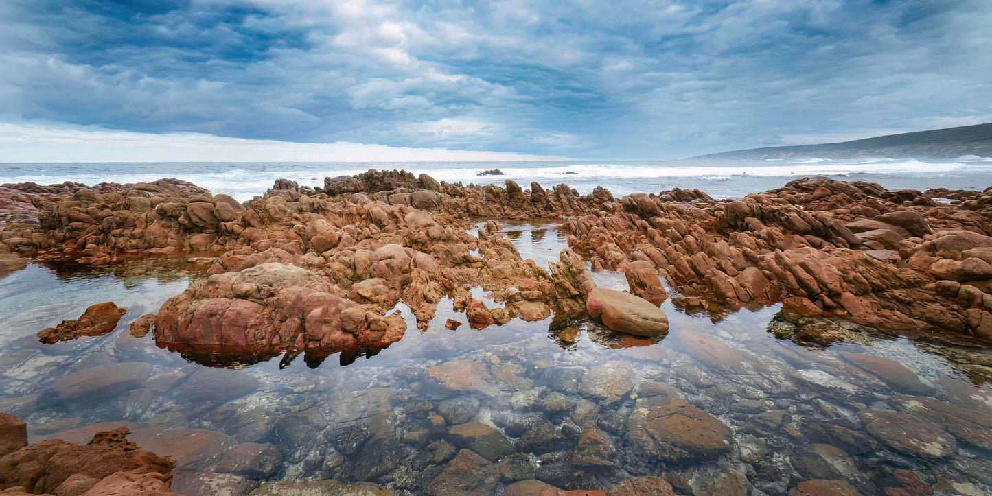 Rocks on a beach at Yallingup with stormy sky and clouds.