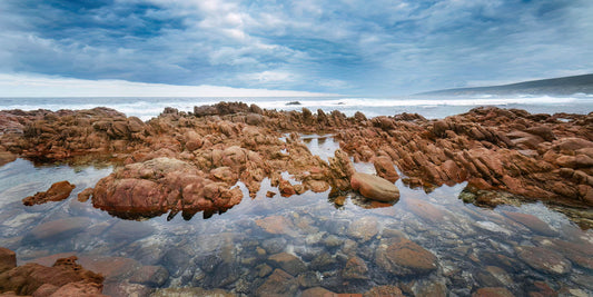 Rocks on a beach at Yallingup with stormy sky and clouds.