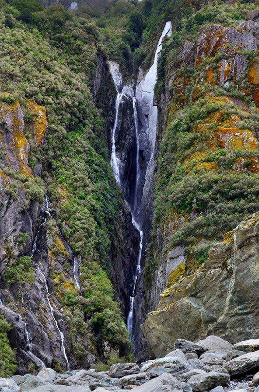 landscape photograph of giant waterfall near fox glacier new zealand